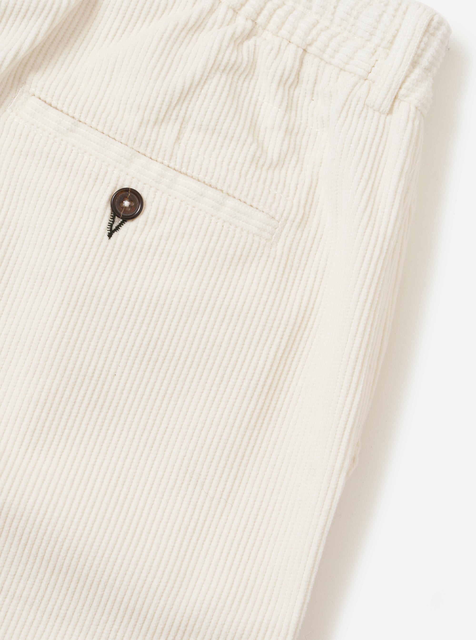 Close-up of the Ecru Cord Pleated Track Pant on a white background. Shows the corduroy texture and button detail.