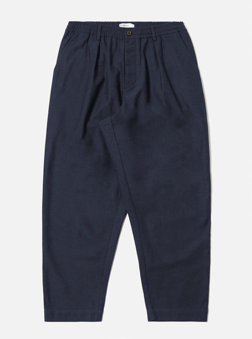The Navy Lucca Suiting Pleated Track Pant in navy on a white background. The pants have a relaxed fit and an elastic waistband.