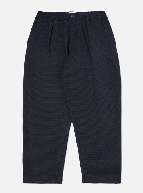 The Navy Brushed Bari Oxford Pant, a relaxed fit in brushed navy fabric, is laid on a white surface. The pants have a subtle texture and a comfortable, casual style.