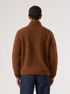 Back view of a model in a Cumin Alvar Fleece Lancaster Jacket. The jacket is brown fleece. Shot against a white background.