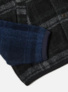 Close-up of the Grey Moh Check Fleece Button Front Bomber. Features a grey and black check pattern with a blue sleeve. The image is shot on a white background.