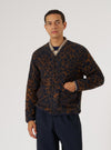 A model poses in a Dark Navy/Brown Night Leopard Cardigan against a white backdrop. The cardigan features a unique leopard print and button-up design.