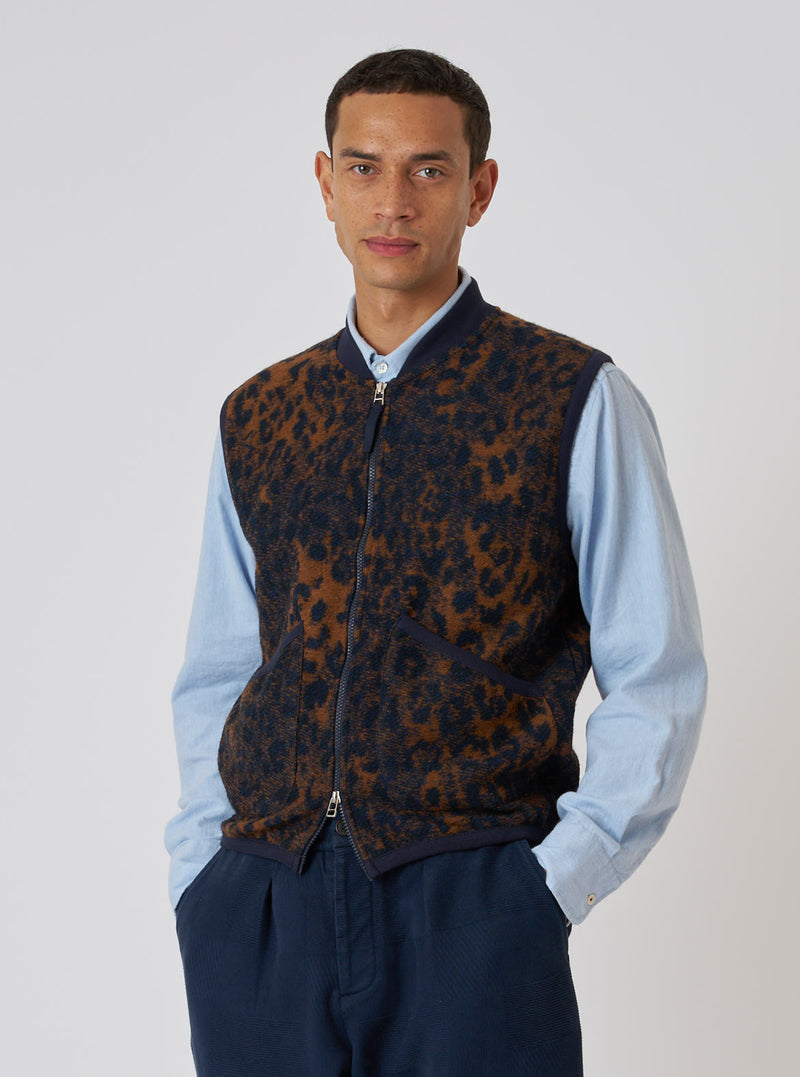 A model poses in a Dark Navy/Brown Night Leopard Zip Waistcoat against a white backdrop. The waistcoat features a unique leopard print and a zip-up design.