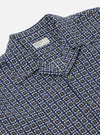 Close-up of the Navy Oscar Cotton L/S Camp Shirt on a white background. The shirt features a navy, white, and gold pattern. The fit is relaxed. 