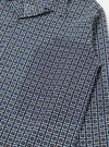 Close-up of the Navy Oscar Cotton L/S Camp Shirt. The shirt has a navy base with a white, black, and orange square pattern. The fabric is cotton and the fit is relaxed. Shot on a white surface.