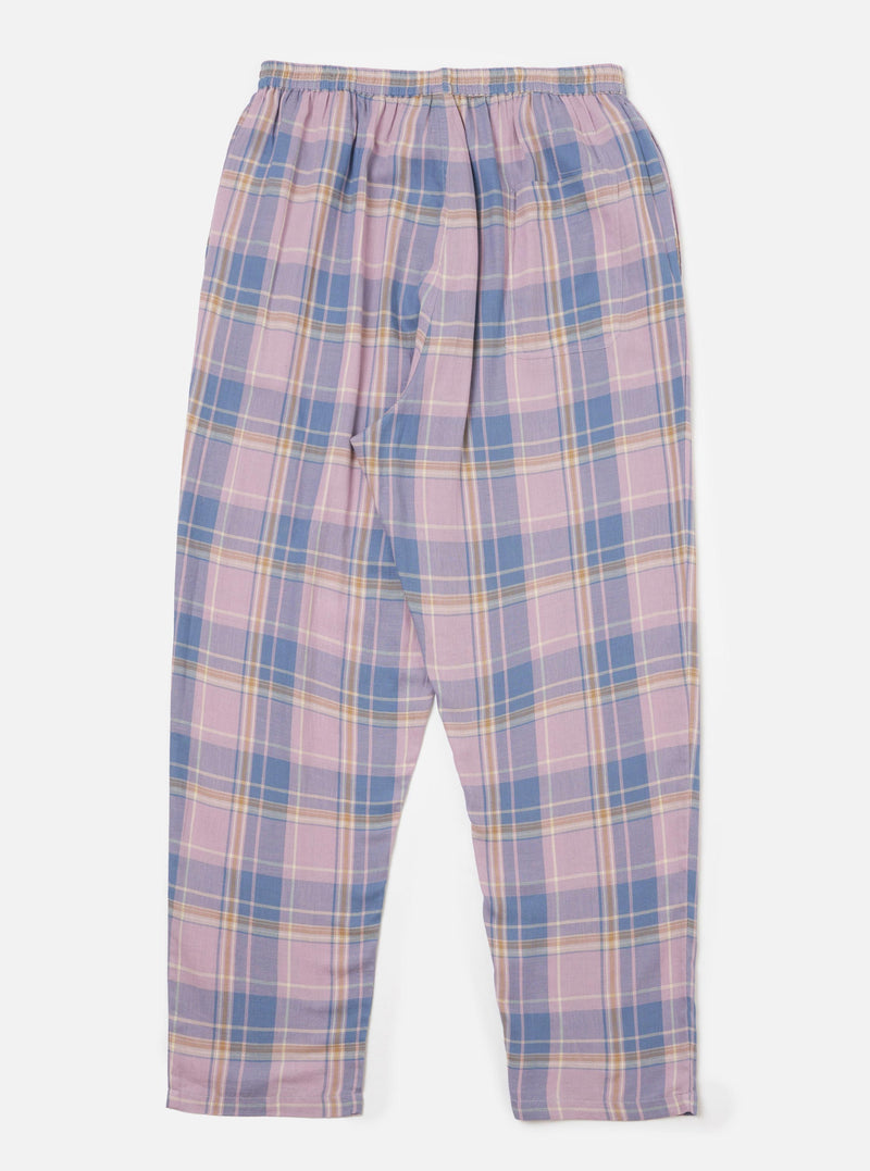 The Pink/Blue Pastel Plaid Pyjama Pant is laid flat on a white background. The pants have an elastic waist and a relaxed fit. The plaid pattern features pink, blue, and cream colors.