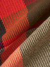 Close-up of the Red Earth Check Long Pyjama Set fabric. The material is a woven check pattern in red, brown, and cream. The fabric is draped to show texture.