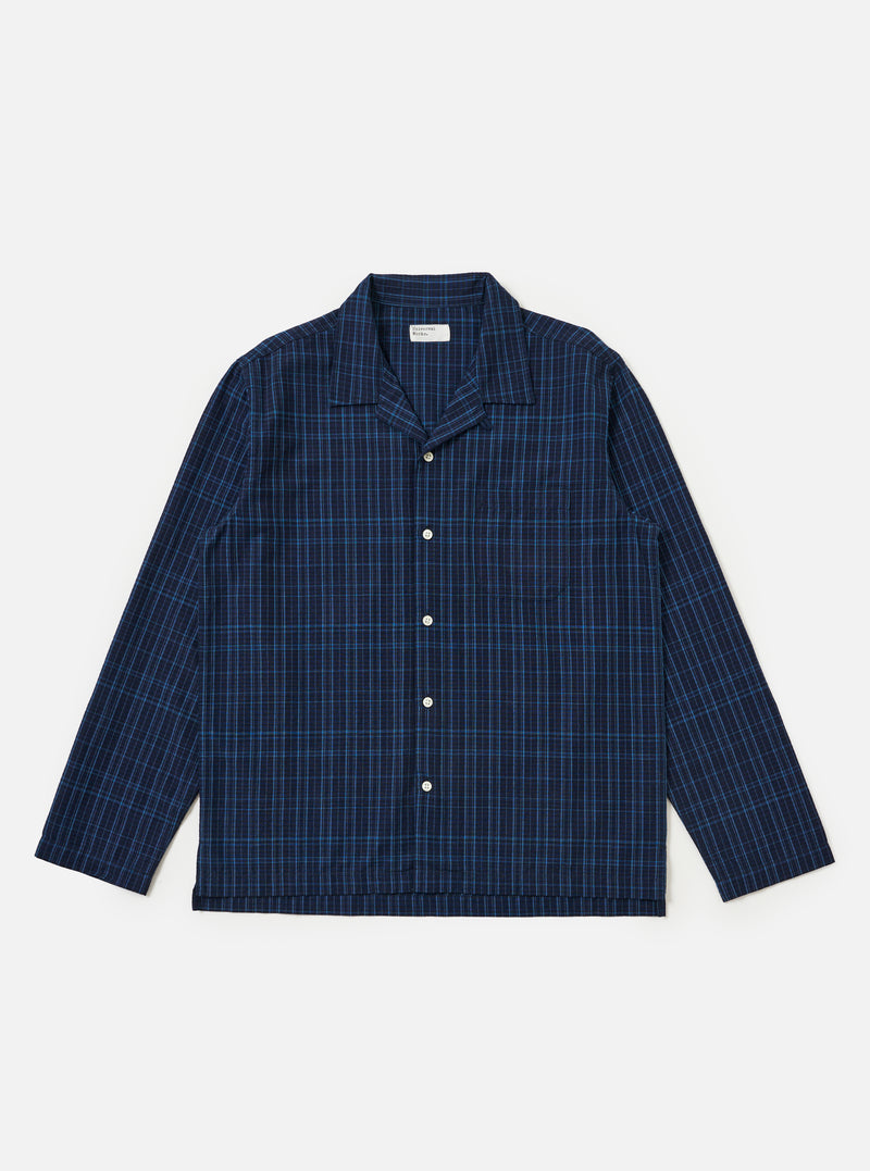 Flat lay of the Indigo Plaid Long Pyjama Set top on a white background. The top is blue plaid with long sleeves and white buttons.