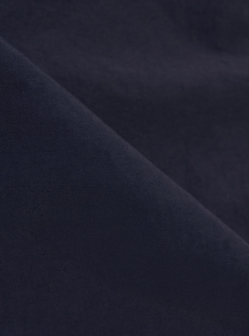 A close-up fabric swatch of the Navy Seo Recycled Nylon Boston Parka highlights the deep navy blue color and the lightweight, tightly woven texture of the recycled nylon material.