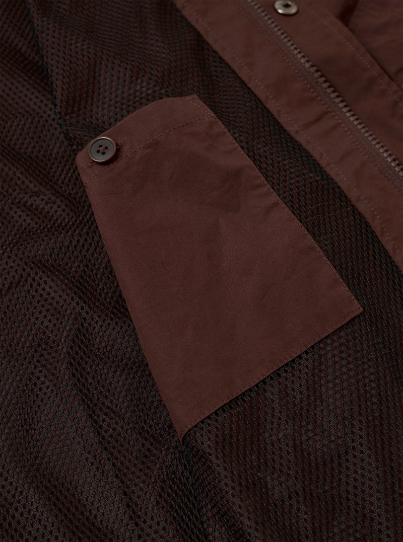 The Brown Peached Poplin NS Bomber Jacket is shown as a flat lay against a plain white background. The jacket features a ribbed collar, a full-length central zipper, and two large slanted patch pockets at the waist. The cotton poplin fabric has a smooth, matte brown finish.