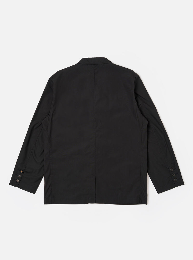 The Black Recycled Polytech Capitol Jacket is shown from the back as a flat lay against a plain white background. The image highlights the smooth black fabric, a single rear vent at the hem, and the clean construction of the shoulders and sleeves.