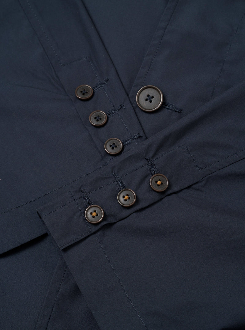 The Navy Recycled Polytech Capitol Jacket is shown from the back as a flat lay against a white background. This unstructured blazer features a single back vent, long sleeves with functioning button cuffs, and a notched lapel. The fabric has a smooth, matte navy blue finish.