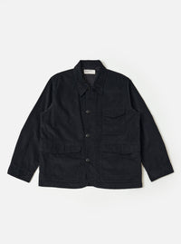 The Black Organic Fine Cord Duty Jacket is shown as a flat lay against a plain white background. The jacket features a spread collar, a central button-front closure, two large double-flap hip pockets, and a single chest patch pocket. The fine-wale corduroy texture is visible across the black organic cotton fabric.