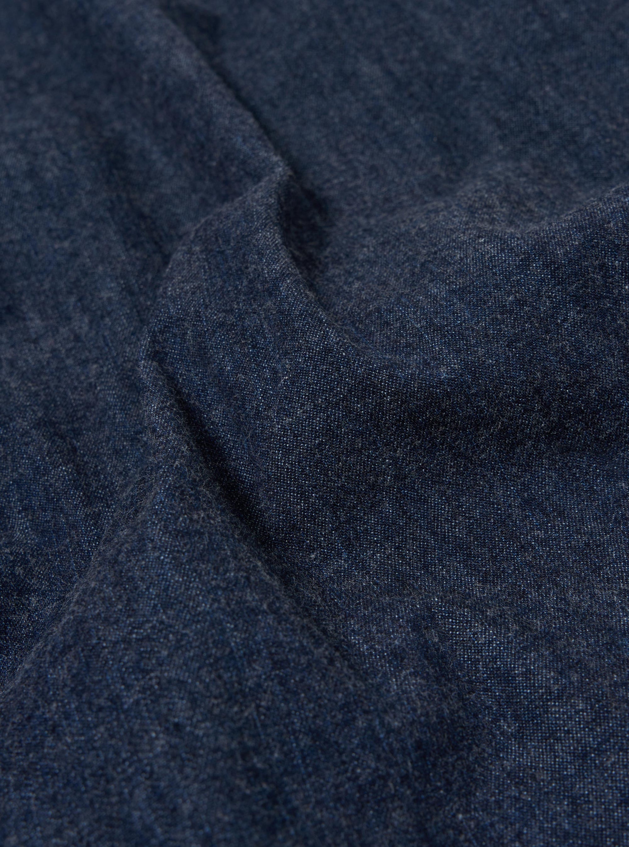 A close-up swatch of the Indigo Kaihara LT WT Denim Kyoto Work Jacket highlights the deep indigo blue color and the fine, diagonal twill weave of the lightweight denim fabric. The texture is consistent throughout the frame, showing no other garment features or models.