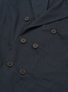 The Navy Twill Manor Jacket is shown from the back as a flat lay against a plain white background. The image highlights the double vents at the hem, the structured shoulders, and the smooth navy blue cotton twill fabric.