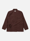 The Brown Peached Poplin Osaka Work Jacket is shown as a flat lay against a white background. The jacket features a wrap-front design with external ties, two lower patch pockets, and two chest patch pockets, one of which has a button-down flap. The brown cotton fabric has a smooth, matte finish.