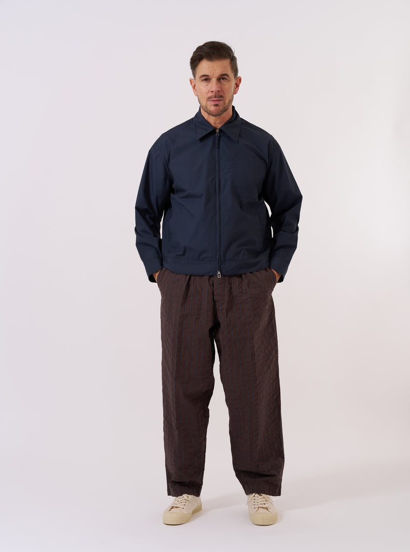 The Navy Recycled Polytech Rose Bowl Jacket is shown as a flat lay against a plain white background. The jacket features a full-length silver zip front, a slightly oversized collar, two slanted welt pockets, and a large patch pocket on the left chest. The dark navy fabric has a smooth, matte finish.