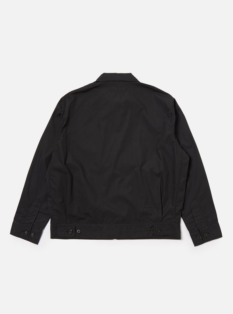 The Black Recycled Polytech Rose Bowl Jacket is shown from the back as a flat lay against a plain white background. The image highlights the garment's boxy fit, oversized collar, and distinctive pleats at the back and cuffs. The adjustable back hem with button detailing is also visible on the smooth, dark fabric.