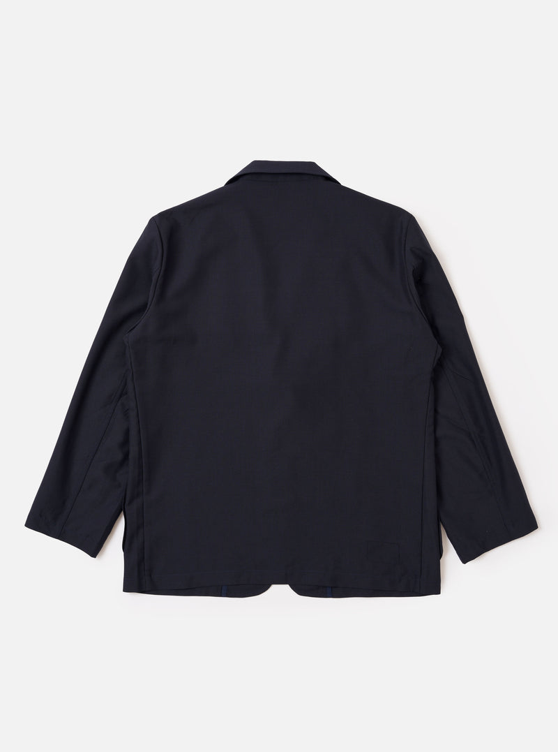 The Navy Tropical Suiting Two Button Jacket is shown from the back as a flat lay against a plain white background. The image highlights the clean, simple construction of the jacket's rear, the two-piece sleeve design, and the smooth texture of the navy tropical suiting fabric.
