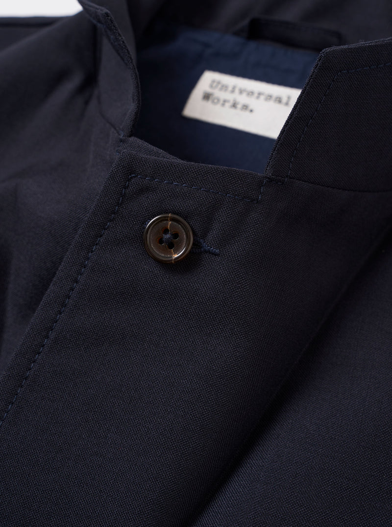 The Navy Tropical Suiting Two Button Jacket is shown from the back as a flat lay against a plain white background. The image highlights the clean, unstructured silhouette of the rear panel, the two-piece sleeves, and the smooth texture of the navy blue tropical suiting fabric.