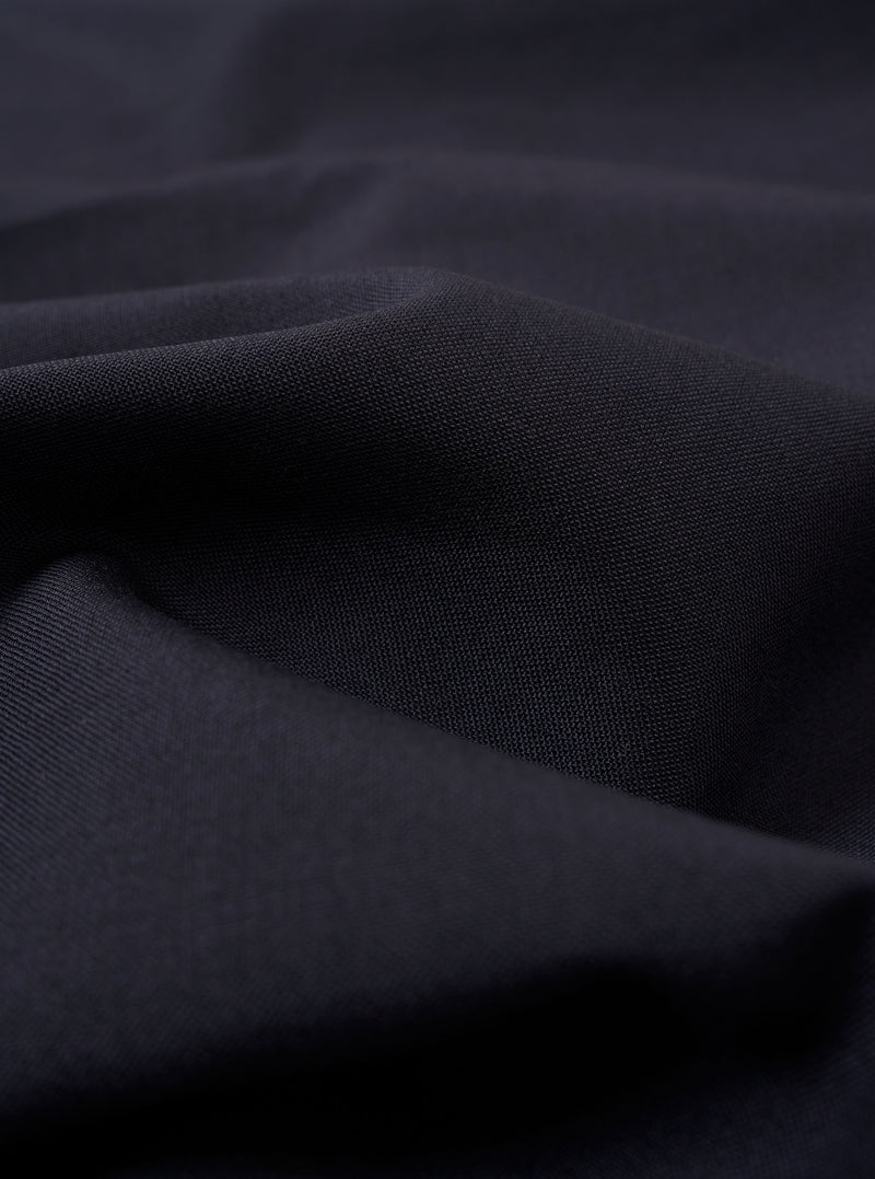 The Navy Tropical Suiting Military Chino is shown as a flat lay against a white background. The image highlights the side profile of the trousers, showcasing the waistband with belt loops, the side pocket, and the clean, straight leg. The fabric is a smooth, dark navy tropical suiting material.