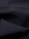 The Navy Tropical Suiting Military Chino is shown as a flat lay against a white background. The image highlights the side profile of the trousers, showcasing the waistband with belt loops, the side pocket, and the clean, straight leg. The fabric is a smooth, dark navy tropical suiting material.