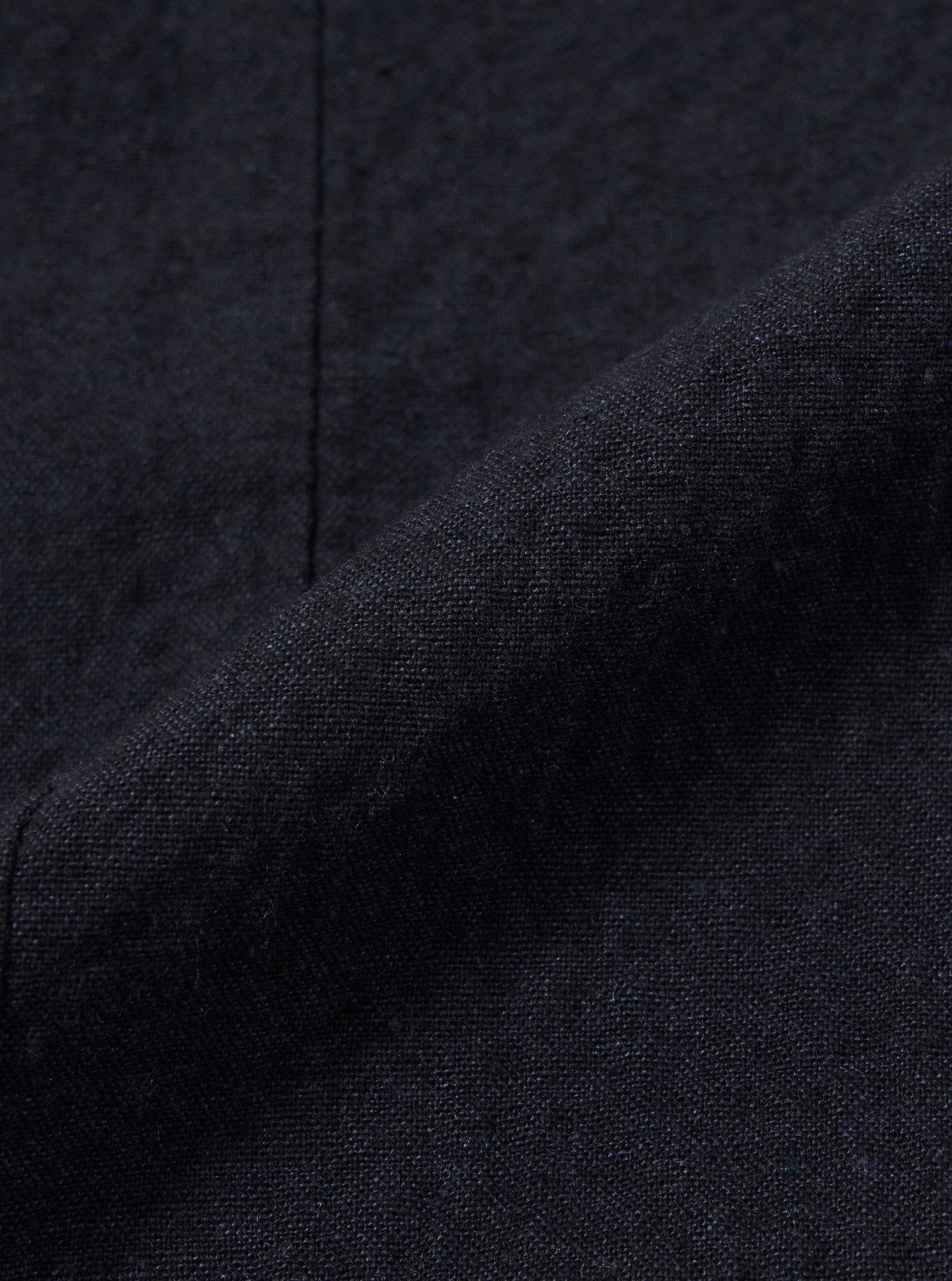 A close-up fabric swatch of the Dark Navy Ospina Cotton Field Waistcoat is shown, highlighting the deep navy blue color and the distinct puckered texture of the seersucker fabric.