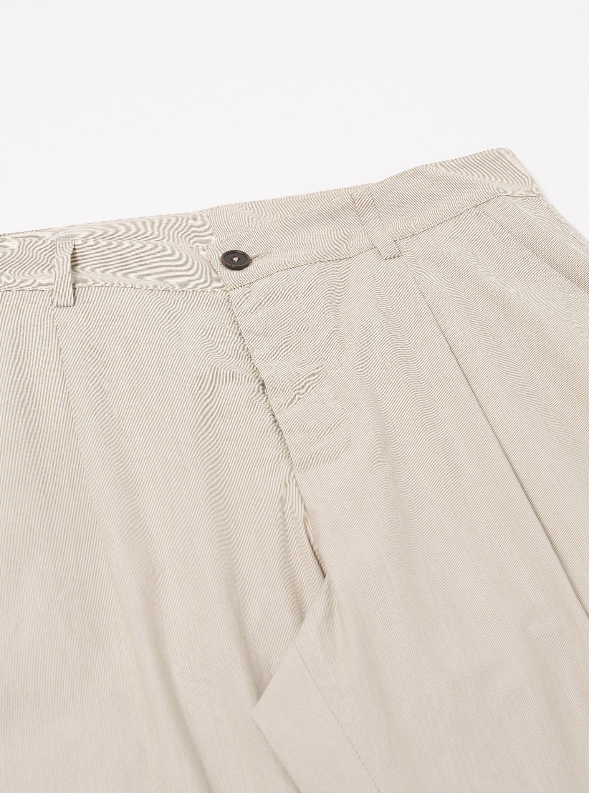 The Brown Kennedy Stripe Duke Pant is shown in a detail view as a flat lay against a plain white background. The image focuses on the construction of the waistband and the fly area, highlighting the brown and white vertical stripe pattern of the cotton fabric. Two side pockets and the pleat detail at the waist are visible.