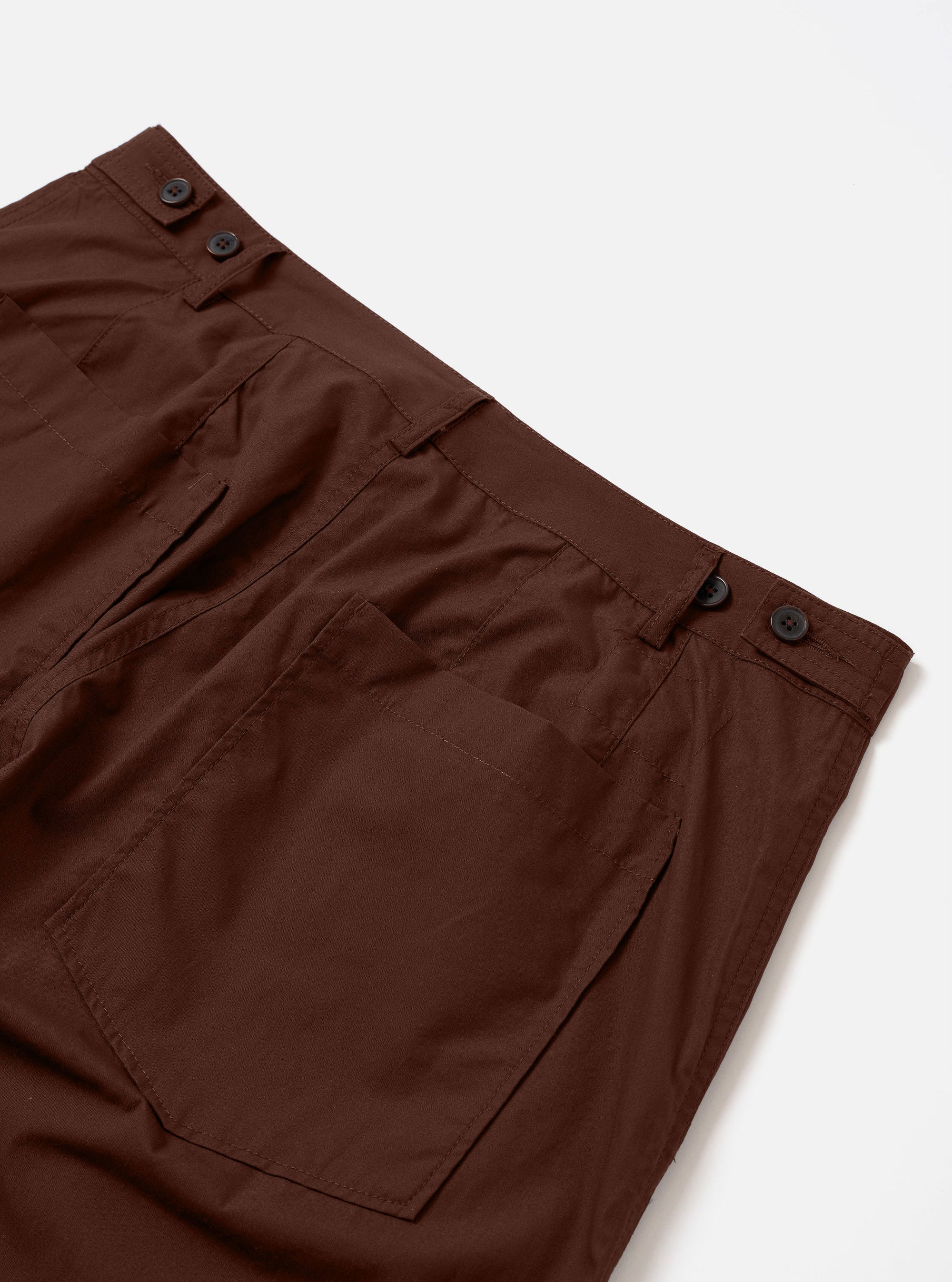 The Brown Peached Poplin Dutch Pant is shown from the rear as a flat lay against a plain white background. The image highlights the wide-leg silhouette and the soft, peached texture of the cotton fabric. Notable details include the rear darts that provide shape to the loose fit and the button-adjust waist.
