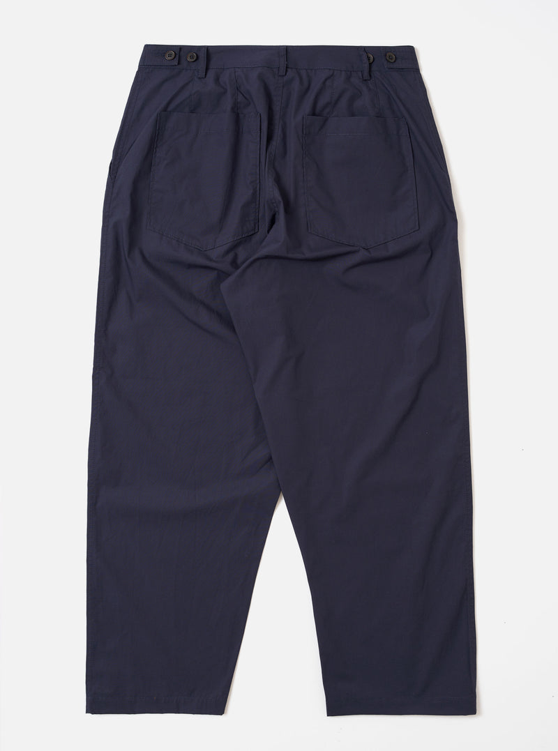The Navy Peached Poplin Dutch Pant is shown from the back as a flat lay against a white background. The image highlights the loose, wide-leg fit and features two large rear patch pockets with button closures and a visible brand label above the right pocket.