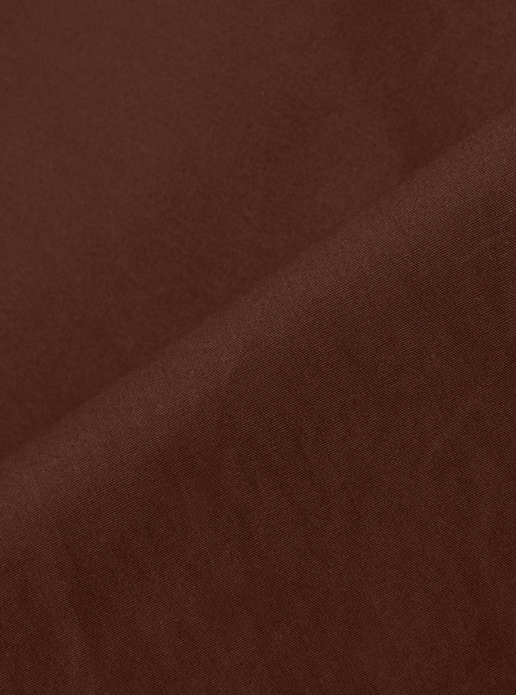 A close-up swatch image of the Brown Peached Poplin Dutch Pant fabric. The image focuses on the brown cotton material, highlighting its smooth, peached texture and consistent color. The background is a plain white.