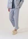 A model wears the Navy Kennedy Stripe Hi Water Trouser, shown from the waist down against a plain white background. The trousers feature a slim, cropped fit with a distinct vertical white stripe pattern on a navy base. The model is wearing them with white socks and dark shoes, highlighting the shortened length and straight hem of the garment.