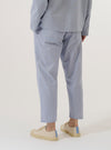 A model wears the Navy Kennedy Stripe Hi Water Trouser, shown from a rear three-quarter angle against a plain white background. The trousers feature a slim, cropped fit and a vertical stripe pattern throughout. The garment includes a drawstring waistband and a single rear patch pocket on the right side.