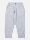 The Navy Kennedy Stripe Hi Water Trouser is displayed as a flat lay against a plain white background. The trousers feature a vertical pinstripe pattern, an elasticated waistband with a drawstring, and two side pockets. The design has a slim, cropped fit with a straight hem.