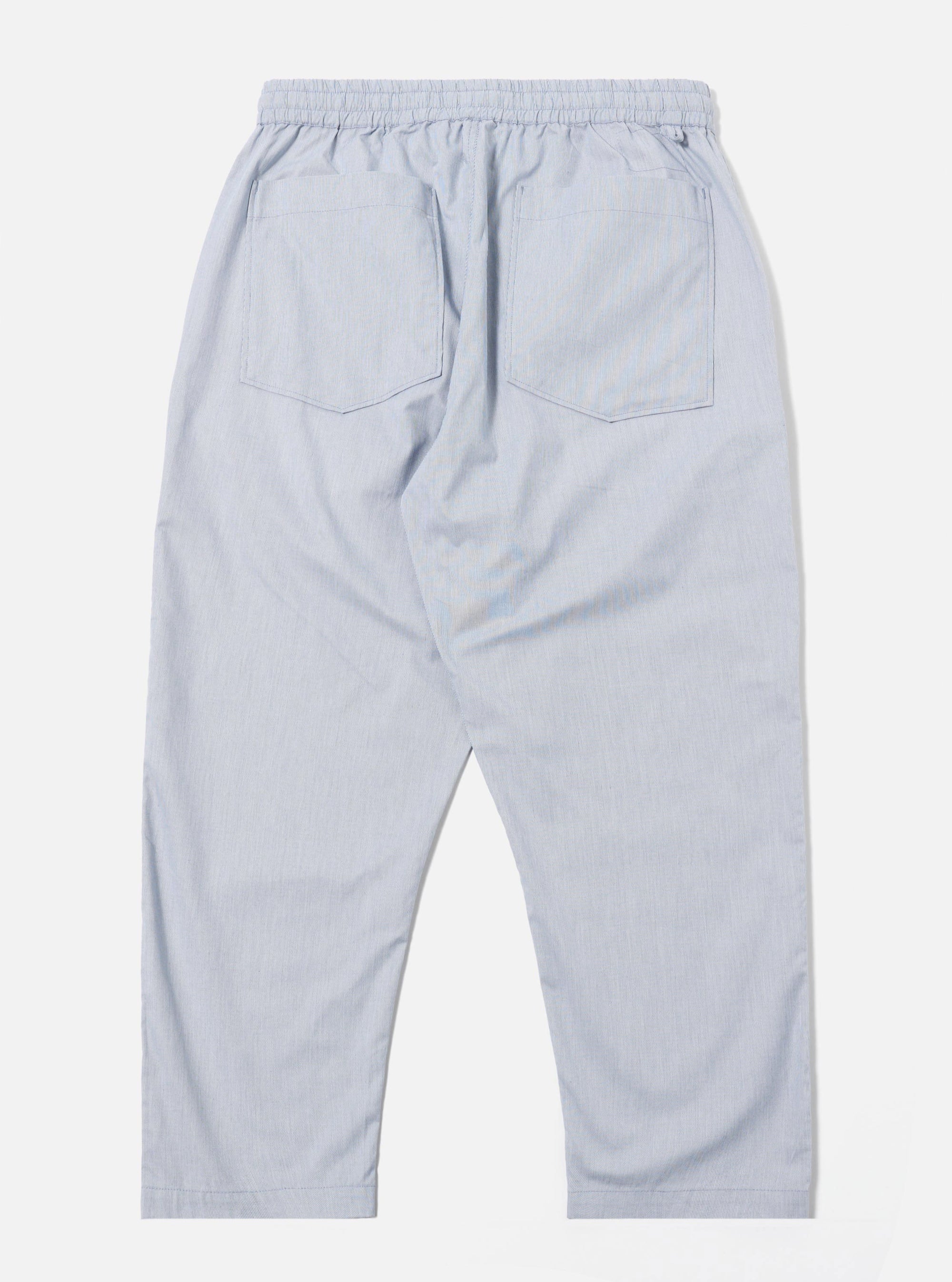The Navy Kennedy Stripe Hi Water Trouser is shown from the back as a flat lay against a plain white background. The image highlights the two rear patch pockets and the elasticated drawstring waistband. The navy blue cotton fabric features a visible vertical pinstripe pattern.