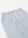 The Navy Kennedy Stripe Hi Water Trouser is shown from the back as a flat lay against a plain white background. The image highlights the two rear patch pockets, one of which features a button-down flap, and the elasticated waistband with visible stitching. The fabric is a navy blue cotton with a fine, vertical white stripe pattern.