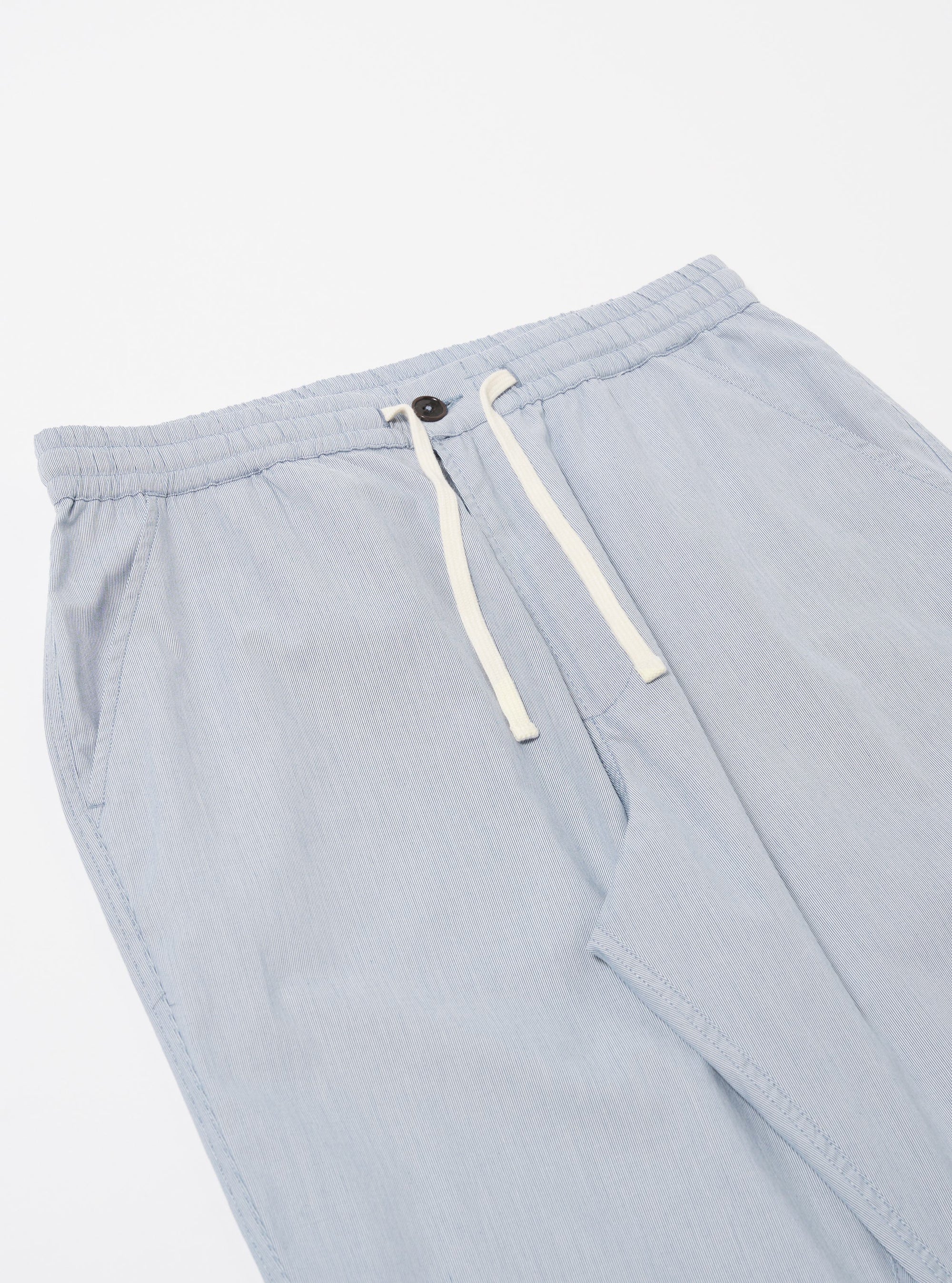 The Navy Kennedy Stripe Hi Water Trouser is shown from the back as a flat lay against a plain white background. The image highlights the two rear patch pockets, one of which features a button-down flap, and the elasticated waistband with visible stitching. The fabric is a navy blue cotton with a fine, vertical white stripe pattern.