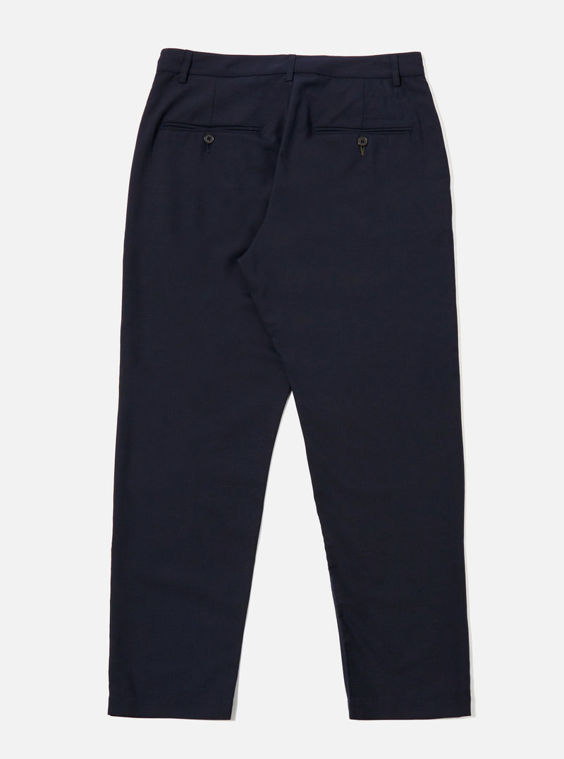 The Navy Tropical Suiting Military Chino is shown from a rear angle as a flat lay against a plain white background. The image highlights the two rear jetted pockets with button closures and the clean construction of the seat. The dark navy fabric, made from a polyester and wool blend, appears smooth and lightweight.