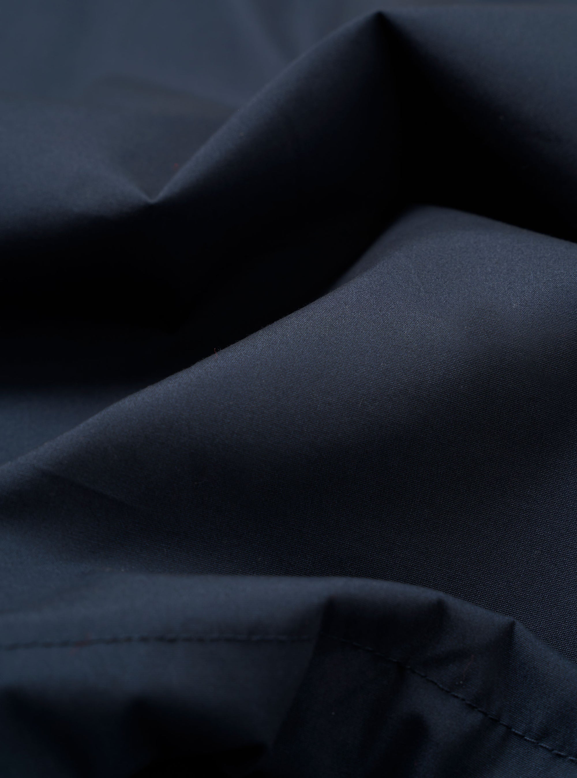 A close-up swatch image of the Navy Recycled Polytech Military Chino fabric highlights the dark navy blue color and the smooth, densely woven technical texture of the recycled polyester and cotton blend.