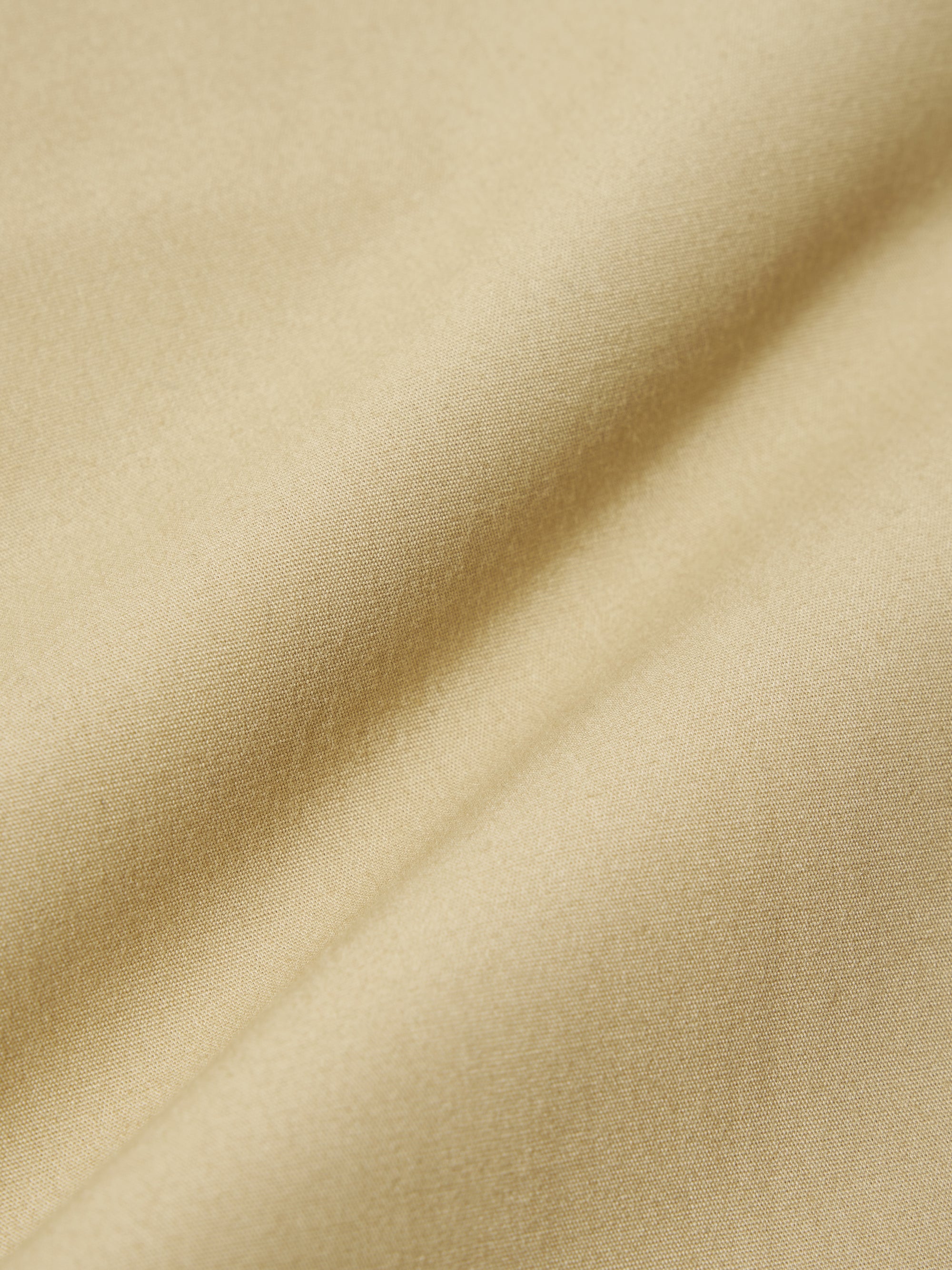 A close-up swatch image of the Sand Recycled Polytech Military Chino fabric. The image focuses on the light sand-colored material, highlighting its smooth, technical texture and tight weave. The background is neutral.