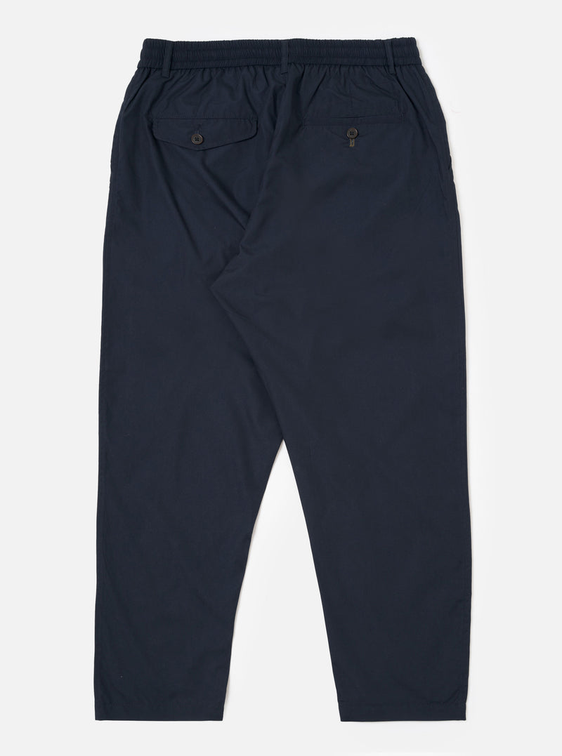 The Navy Recycled Polytech Pleated Track Pant is shown from the back as a flat lay against a plain white background. The image highlights the elasticated waistband and the two rear pockets, featuring one button-down flap pocket and one jetted pocket. The dark navy fabric appears smooth with a technical, utilitarian finish.