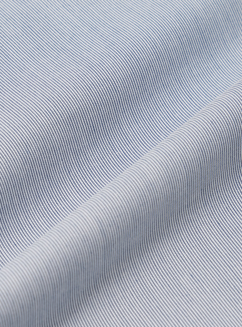 A close-up fabric swatch of the Navy Kennedy Stripe Pleated Track Short highlights the texture and pattern of the material. The navy blue fabric features a distinct vertical stripe design. The material fills the entire frame, providing a detailed view of the garment's color and construction.