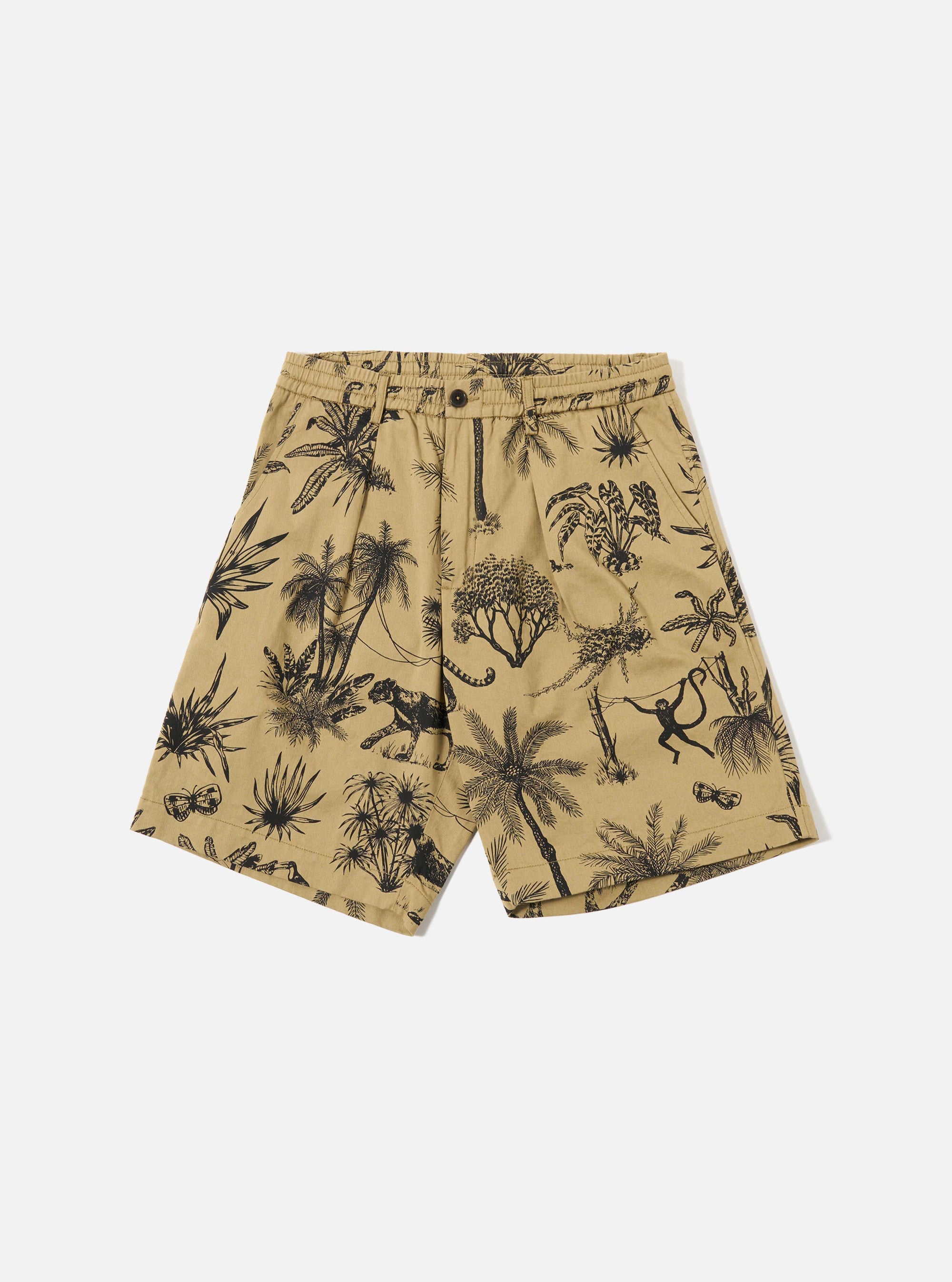 The Sand Jungle Toile Twill Pleated Track Short is shown as a flat lay against a plain white background. The shorts feature a prominent all-over dark jungle toile print on a sand-colored base, an elasticated waistband with a button fly, a single front pleat, and two side hand pockets. The fabric is a structured cotton twill.