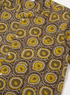 The Olive Cape Block Print Camp Shirt is shown from the back as a flat lay against a plain white background. The image highlights the straight hem, the back of the camp collar, and the intricate, repeating block print pattern featuring botanical motifs in shades of green and brown on an olive base.