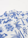 The White Jungle Toile Poplin Camp Shirt is shown from the back as a flat lay against a plain white background. The shirt features a straight hem, a simple back yoke, and a continuous jungle toile print with dark botanical and animal illustrations on an ecru base. The fabric appears lightweight with a smooth poplin texture.