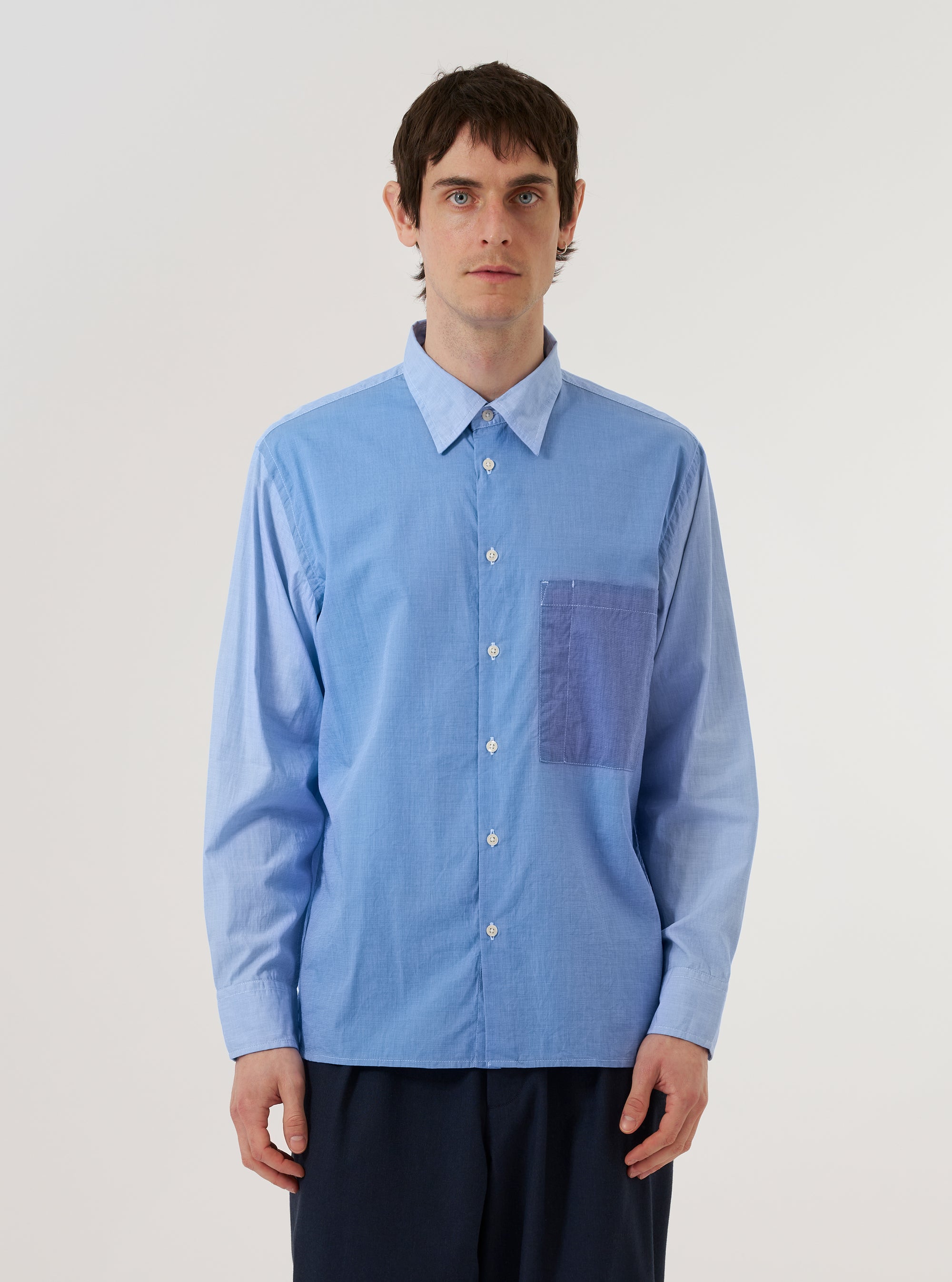 A model wears the Sky/Blue Fil A Fil Mixed Square Pocket Shirt against a plain white background. The shirt features prominent square chest pockets, a button-down front, and a classic collar, showcasing the light blue textured weave of the fabric.