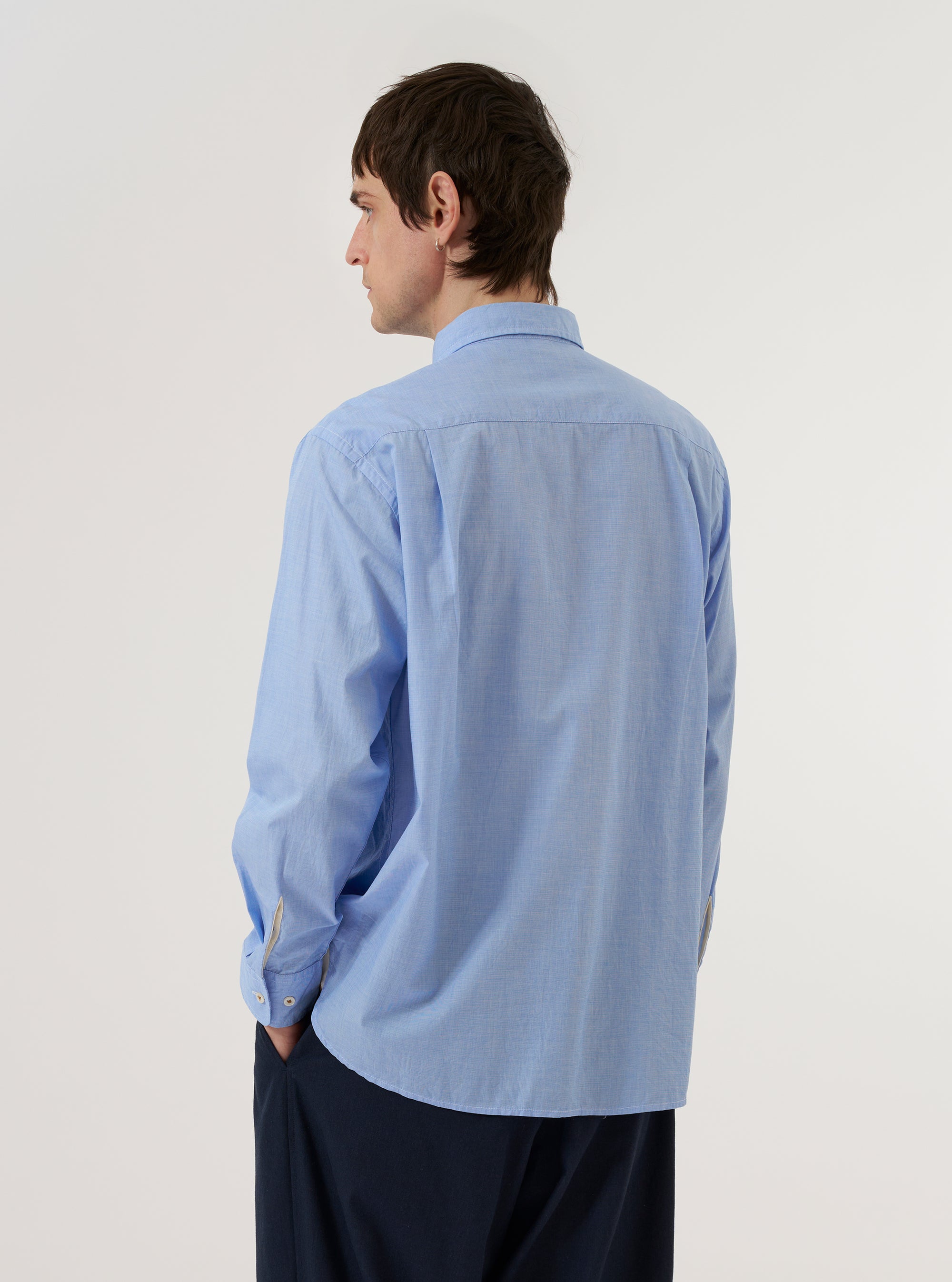 The Sky/Blue Fil A Fil Mixed Square Pocket Shirt is worn by a model against a plain white background. The shirt is shown from a rear three-quarter angle, highlighting the back yoke and the relaxed fit of the sleeves. The model is wearing the shirt untucked over a white t-shirt.
