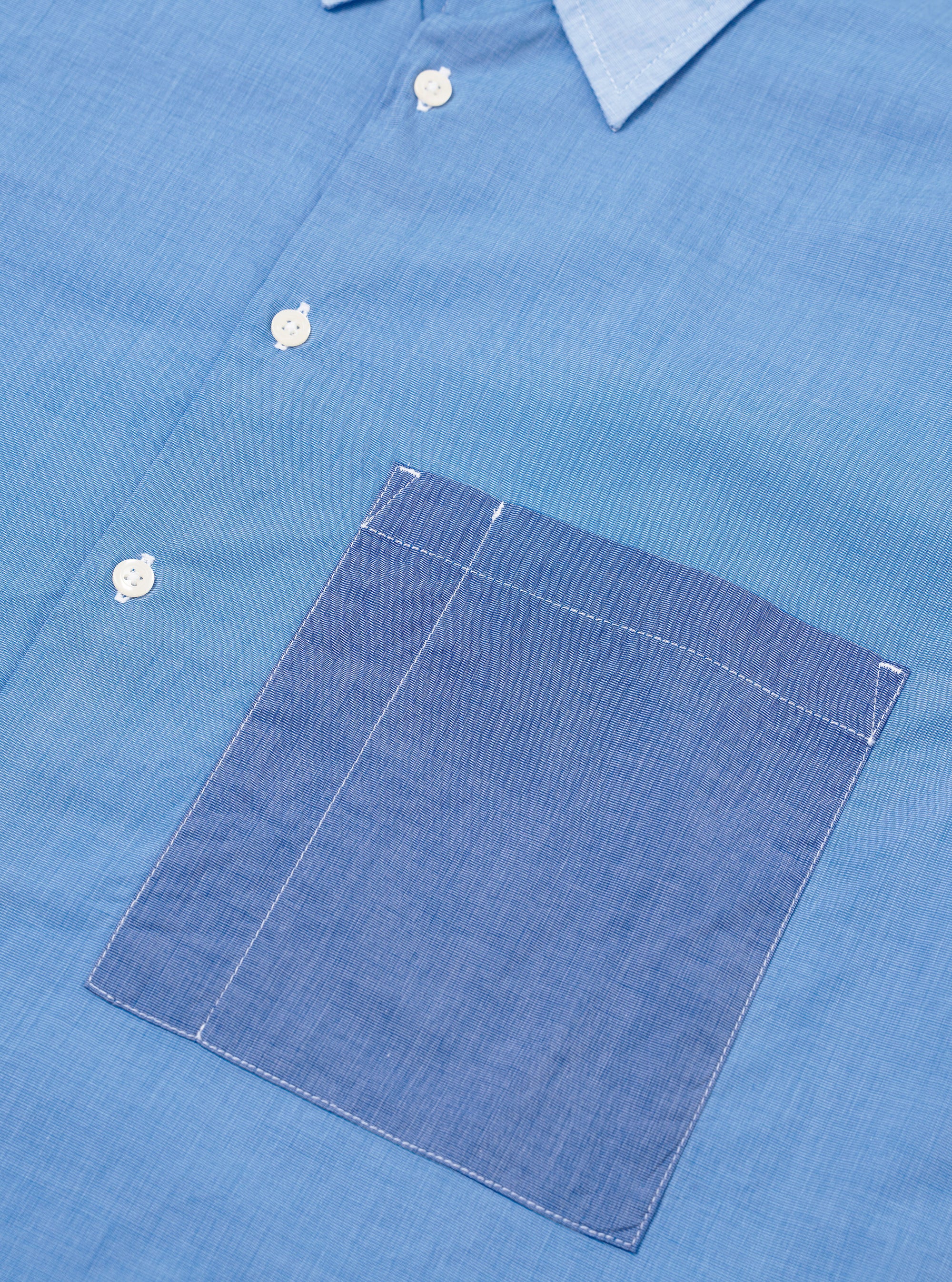 The Sky/Blue Fil A Fil Mixed Square Pocket Shirt is shown from the back as a flat lay against a plain white background. The image highlights the back yoke, the loose fit of the garment, and the adjustable button cuffs on the long sleeves. The light blue fil-a-fil fabric is clearly visible.
