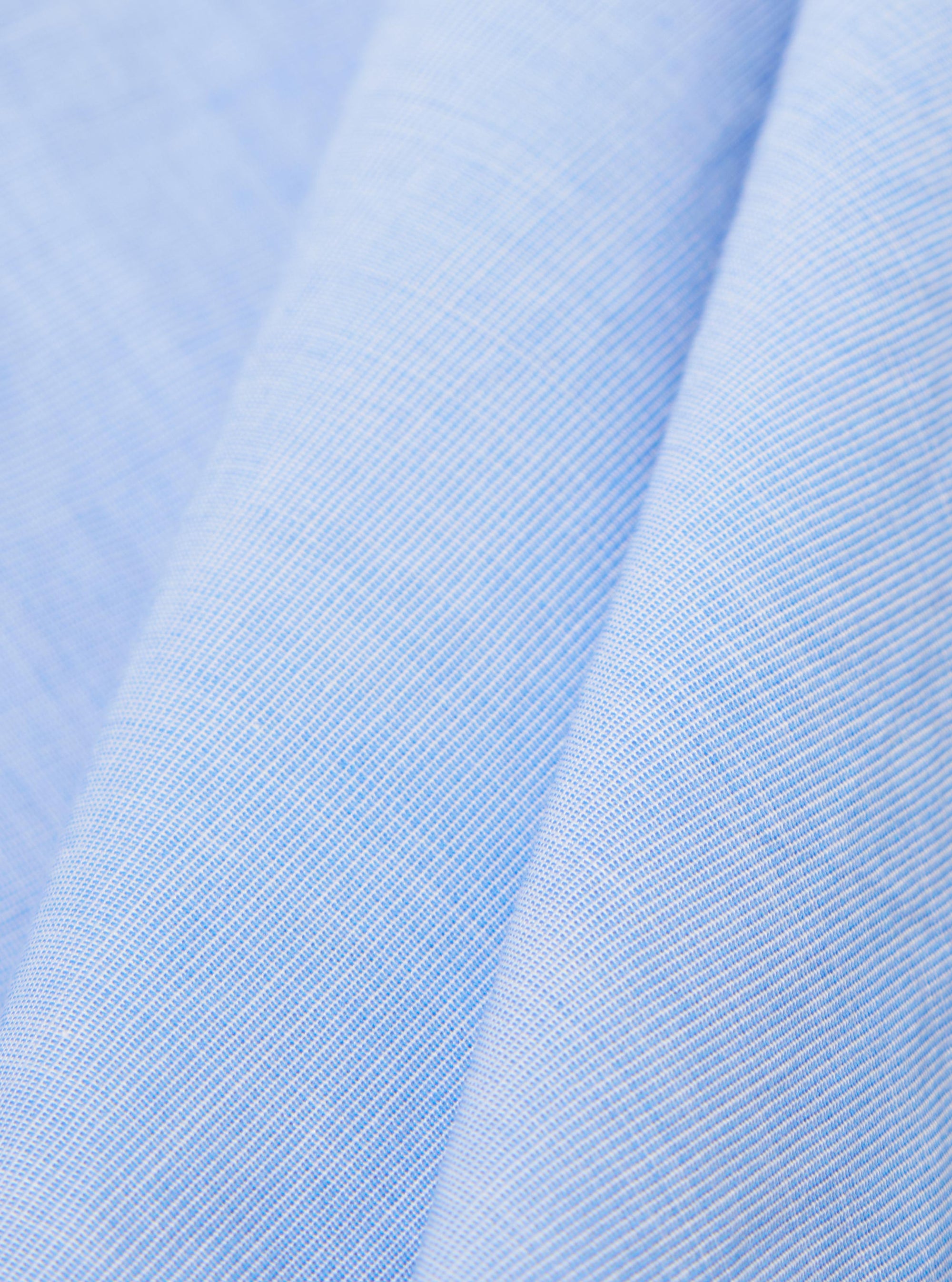 A close-up fabric swatch of the Sky/Blue Fil A Fil Mixed Square Pocket Shirt displays a light blue and white woven texture. The image focuses on the fine, grid-like pattern of the cotton fabric.
