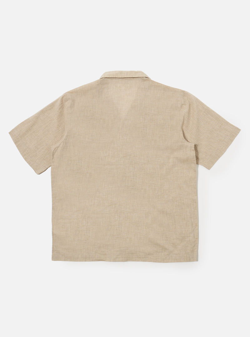 The Beige Fine Organic Cotton Sal Road Shirt is shown from the back as a flat lay against a plain white background. The image highlights the shirt's straight hem, short sleeves, and the soft marled texture of the beige organic cotton fabric.